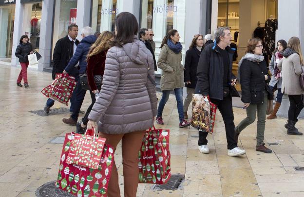 Clientes con bolsas de la compra en Valencia. 