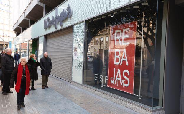 Personas en la puerta de un establecimiento cerrado.