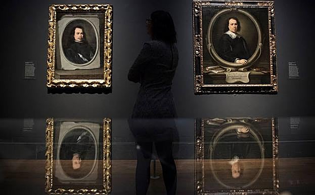 Una mujer observa dos autorretratos de Murillo. 