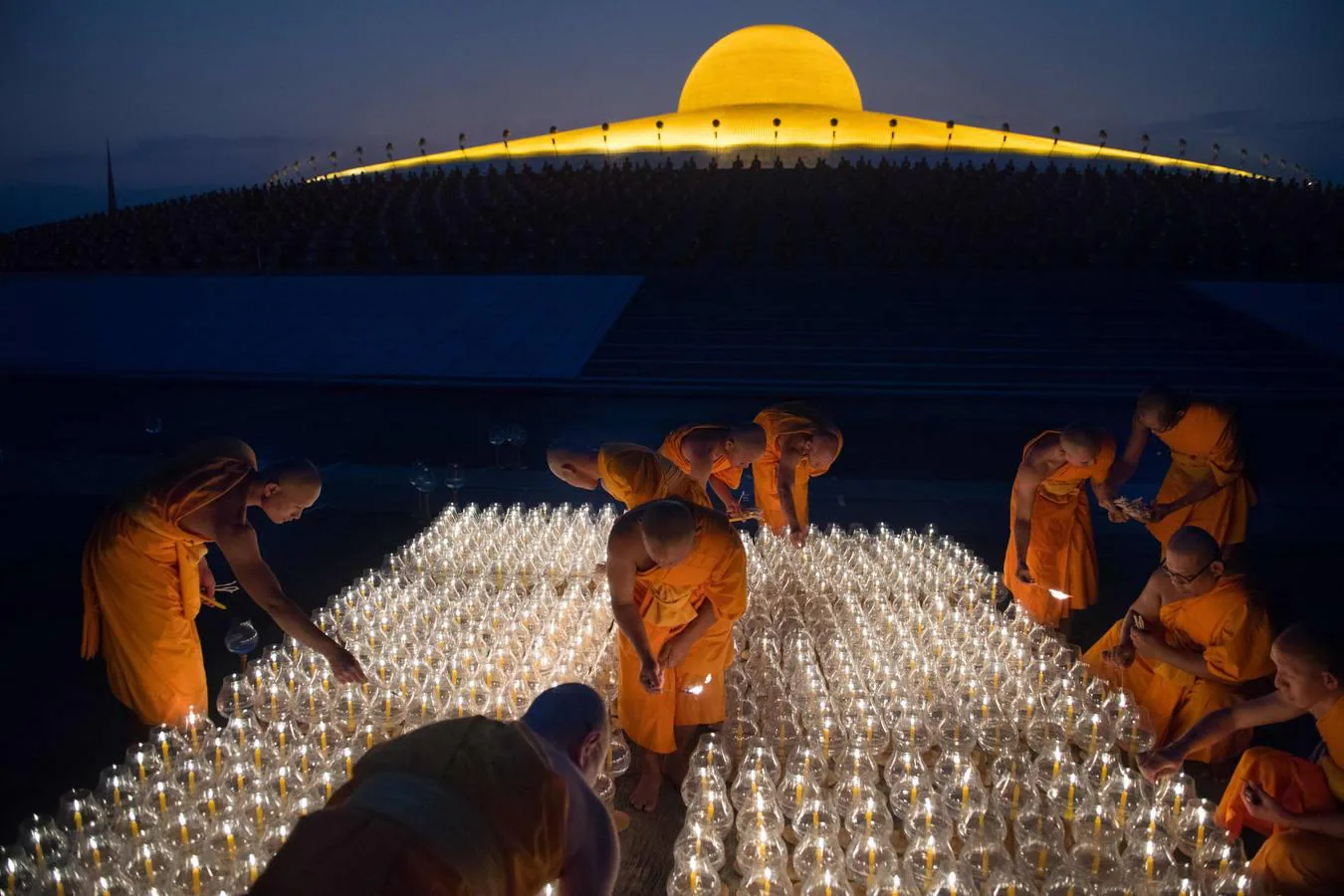 Monjes tailandeses caminan en círculo con velas en el Magha Puja, en el templo Wat Phra Dhammakaya, en la provincia Pathum Thani