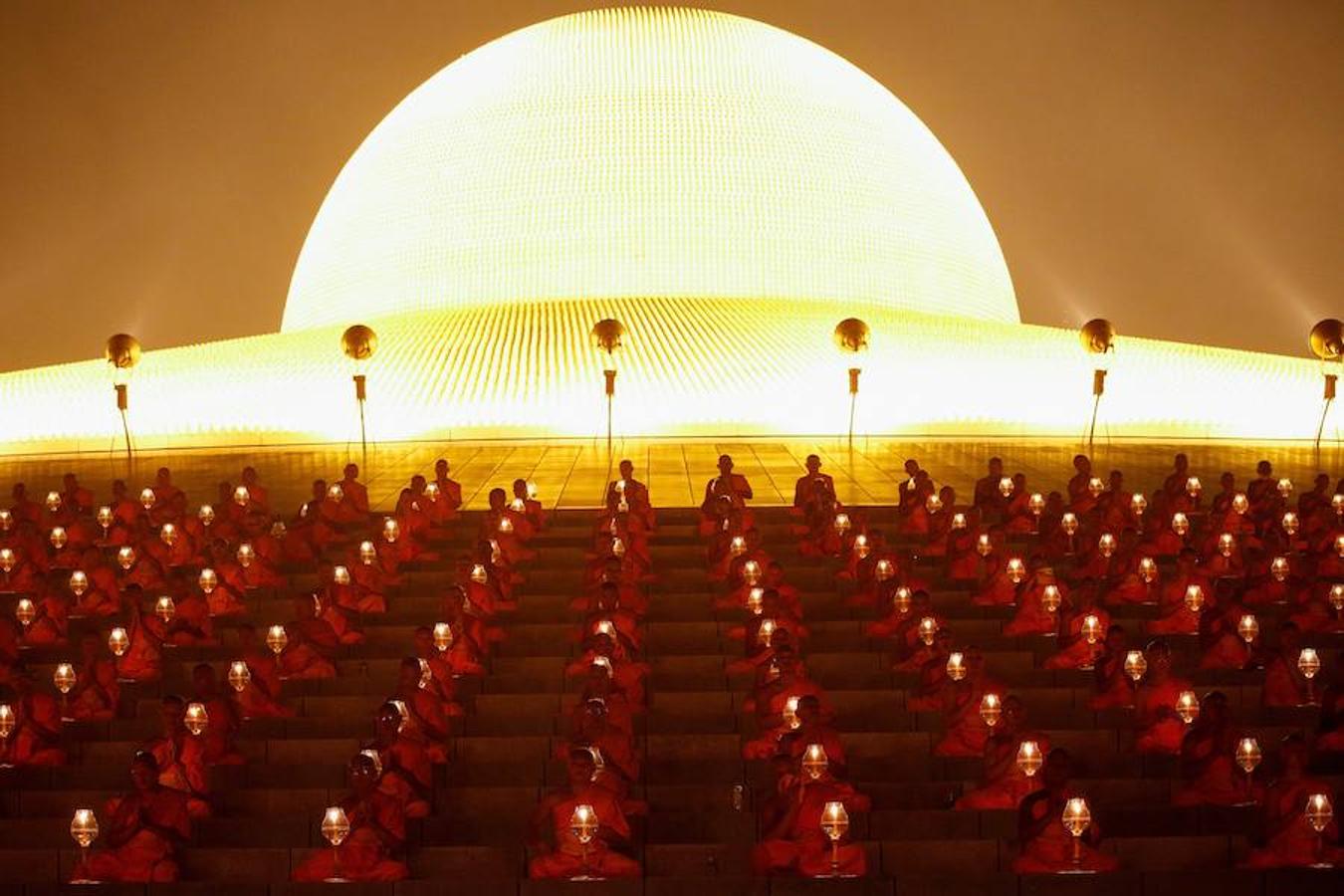 Monjes tailandeses caminan en círculo con velas en el Magha Puja, en el templo Wat Phra Dhammakaya, en la provincia Pathum Thani