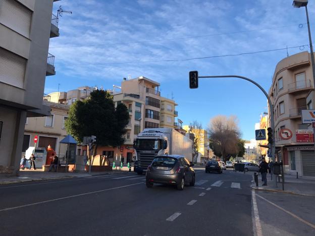 Camiones y vehículos atravesando ayer por la tarde la CV-50 a su paso por el casco urbano de Tavernes. 