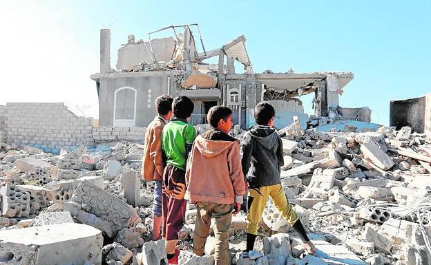 Niños yemeníes ante un edificio derribado por un bombardeo. 