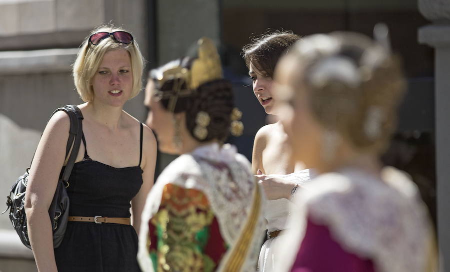 Dos jóvenes turistas observan a las falleras de una comisión.