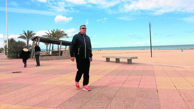 Un turista camina ayer por el paseo marítimo de la playa de Gandia ante las buenas temperaturas. 