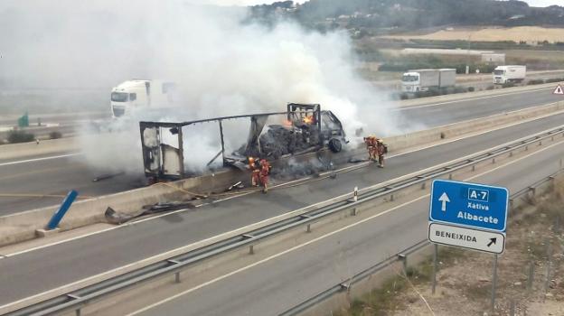 Bomberos extinguen las llamas en el camión. 