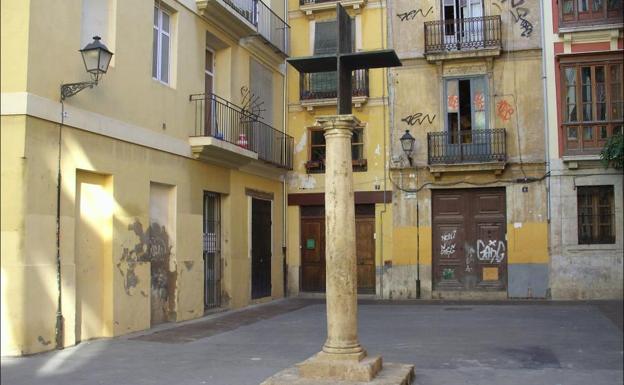 Cruz de hierro unida a la columna de piedra en la Plaza Santa Cruz. 