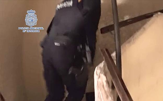 Un policía nacional durante el asalto a la vivienda de los detenidos, en Alicante.