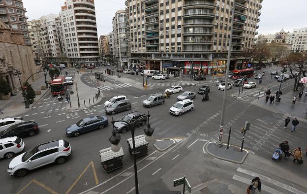 Panorámica de la plaza, con varios cruces, señales apenas visibles en el suelo y hasta tres paradas de autobús. 