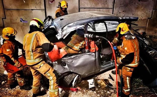 Bomberos liberandoa las personas atrapadas en el accidente.