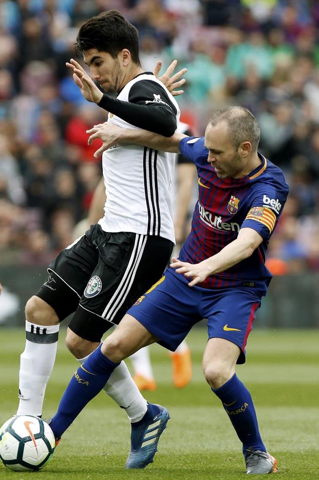 Carlos Soler trata de robarle el balón a Iniesta. 