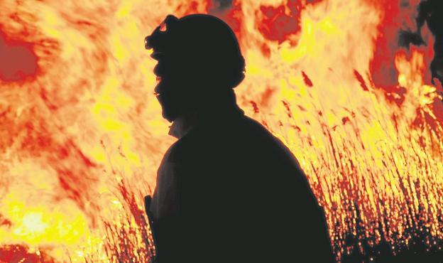 Un bombero trabaja en el incendio del Prat de Cabanes. 