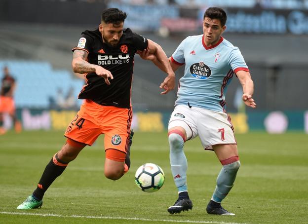 Garay y Maxi Gómez pelean por la posesión del balón en Balaídos. 