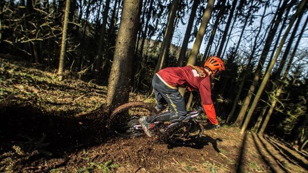 Un ciclista practica mountain bike en un monte. 