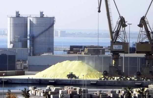 Varias máquinas trabajan en la carga y descarga de graneles al aire libre en el Puerto de la capital alicantina. 