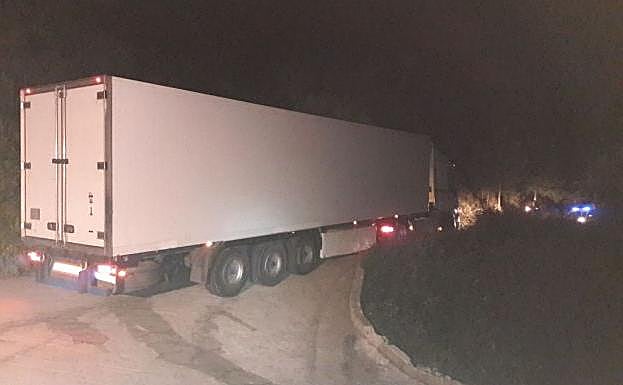 Imagen principal - El camión atrapado y los daños que causó en los bordillos de la carretera.