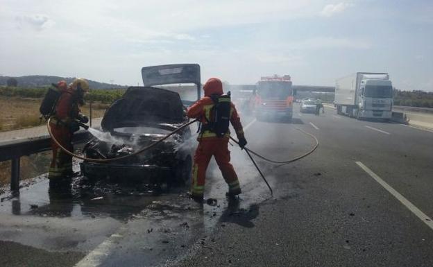 Imagen principal - Los bomberos trabajan en la extinción del incendio en la A-7.