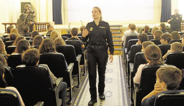 Una policía explica a escolares los riesgos de internet. 