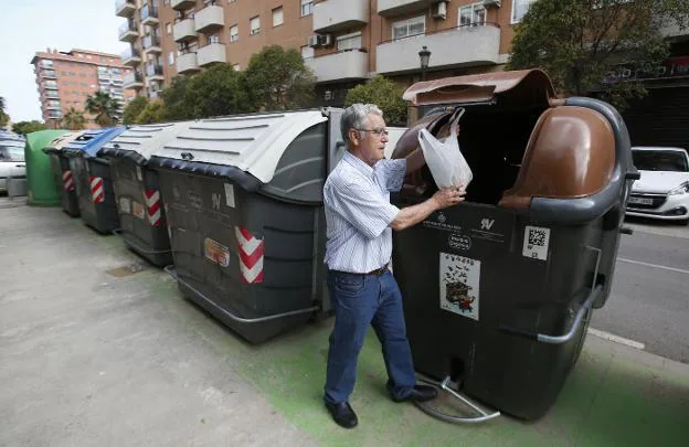 Un vecino de San Marcelino tira al contenedor orgánico su basura, ayer por la tarde. 