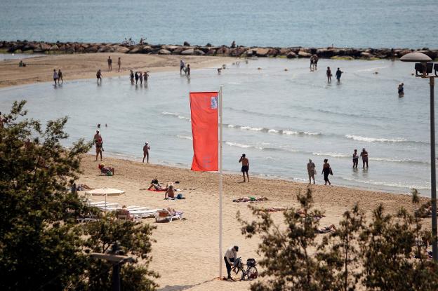 Una playa de Elche ayer con la bandera de prohibido el baño por medusas. 