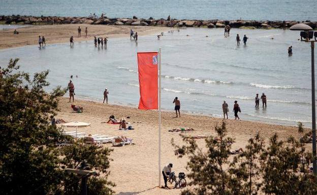 Una playa de Elche ayer con la bandera de prohibido el baño por medusas.