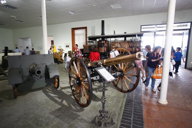 Varios visitantes junto a un cañón histórico. 