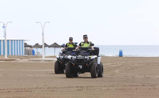 Dos agentes de la Policía Local patrullan por la playa.