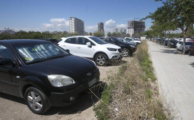 Imagen principal - Vehículos aparcados en un solar de la calle Moreras y sobre las aeras de Orriols y ronda norte. 