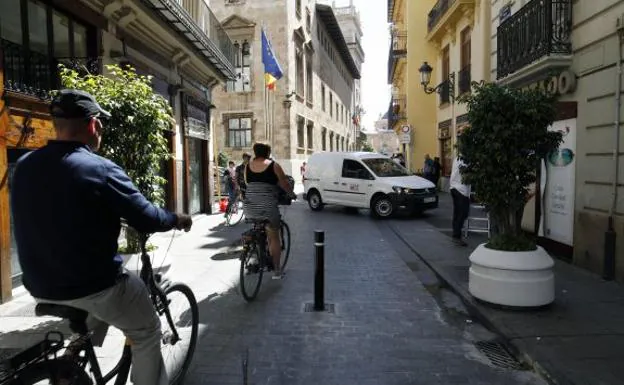 Dos ciclistas pasan junto al bolardo que corta el tráfico en la calle Caballeros, a la altura de la calle Cocinas. 