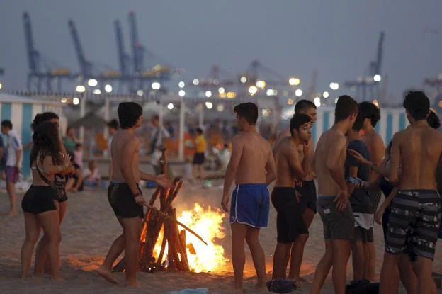 Noche de fiesta. Un grupo de jóvenes disfruta de una hoguera en la noche de San Juan del pasado año en la playa de la Malvarrosa. 