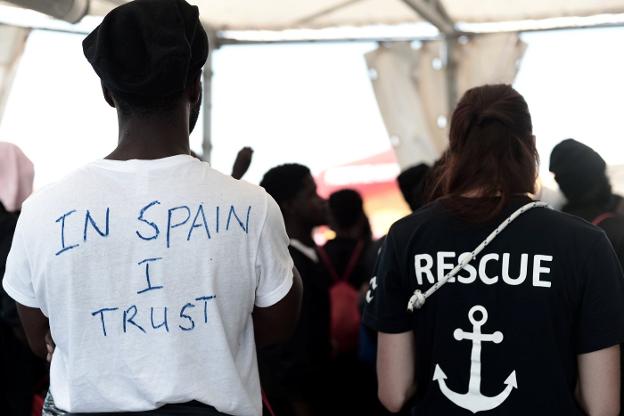 Un rescatado con el lema 'creo en España' y un voluntario, en el 'Aquarius'. 