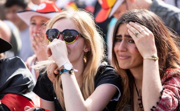 Dos aficionadas alemanas lloran tras la eliminación de su selección.