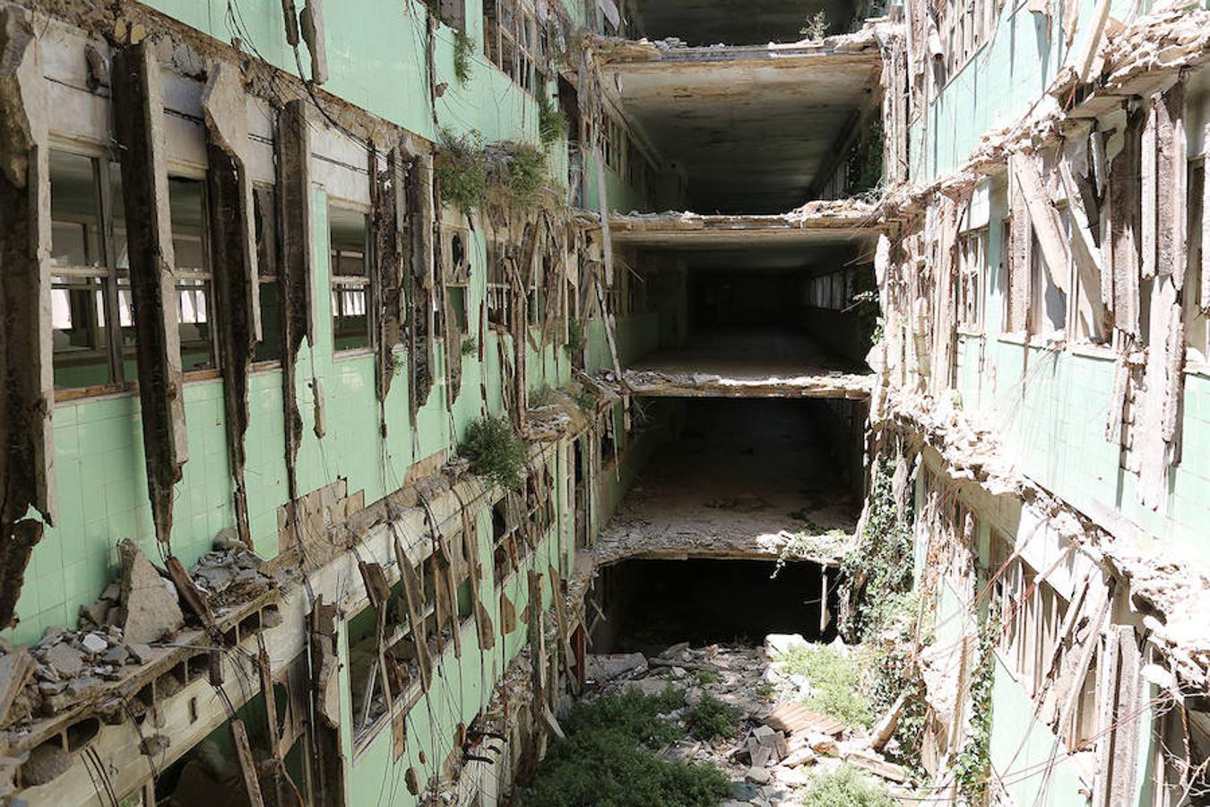 Cuatro plantas de altura, terraza, neveras y lo que queda del mecanismo de un ascensor. Cientos de cuencos y recipientes abandonados. Escritorios con más polvo que madera y cartas firmadas.