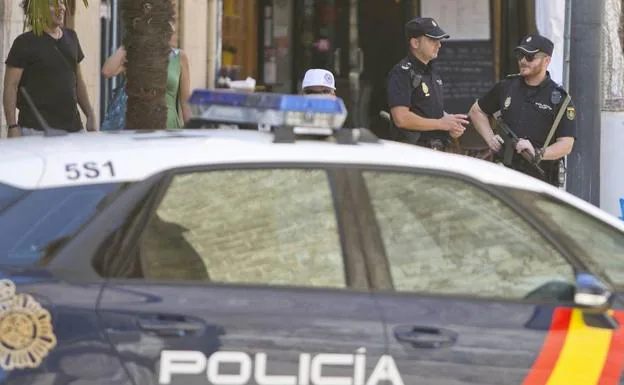 Coche de la Policía Nacional junto a varios agentes