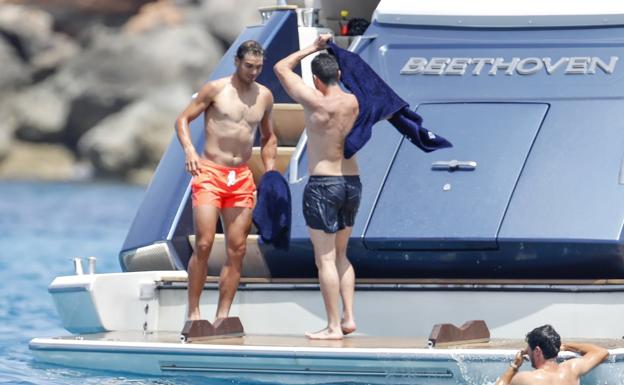 Rafa Nadal, con unos amigos en la plataforma de popa de su yate 'Beethoven' en aguas de Baleares. 