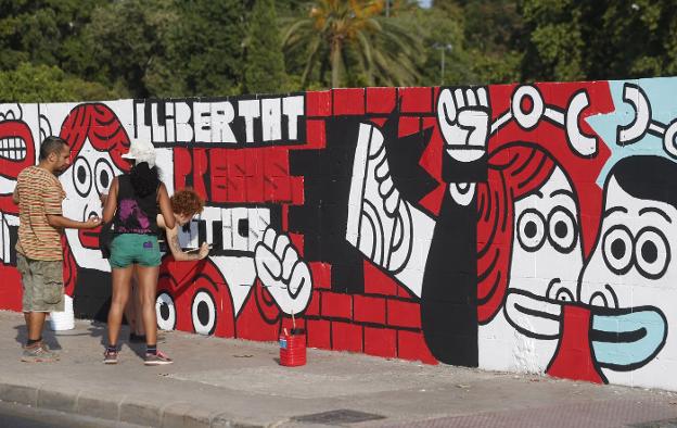 Varias personas pintan el mural contra el fallo de Alsasua, ayer, en Valencia. 