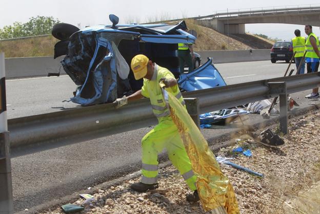 Un operario de mantenimiento de la A-7 retira una manta térmica tras un accidente mortal ocurrido en 2013 en l'Alcúdia. 