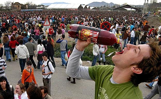 Un joven bebe alcohol en las fiestas de un pueblo.