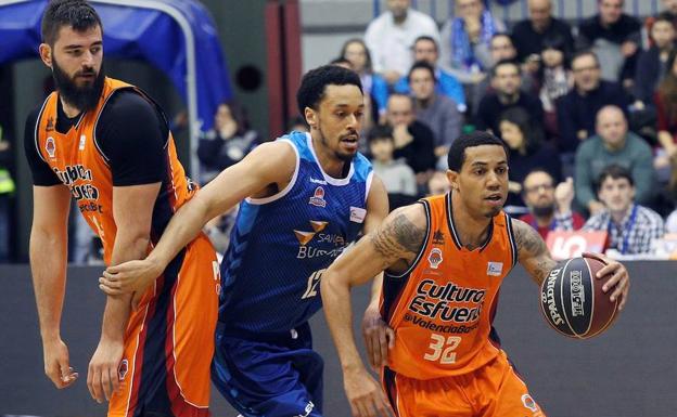 El escolta del Valencia Basket Erick Green (d) avanza con el balón perseguido por John Jenkins (c), y su compañero de equipo el pívot Bojan Dubljevic (i), durante el partido de la vigésima jornada de Liga ACB disputado en el Coliseum Burgos.