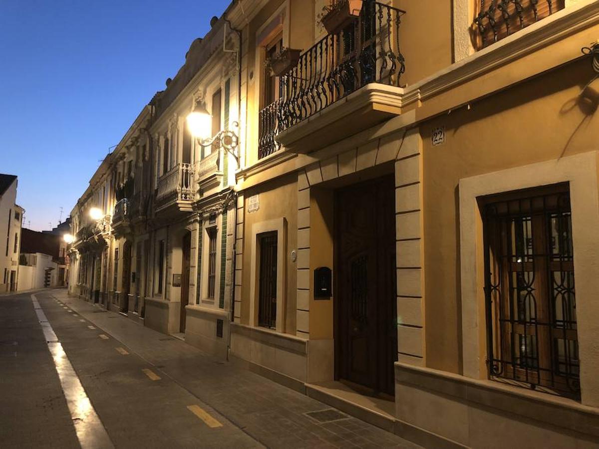 Es una de esas zonas poco conocidas de Valencia. El barrio de Campanar reúne todas esas características que se espera encontrar en un remoto y solitario pueblo, y no en plena urbe. Calles tranquilas, casas antiguas, fachadas con un encanto diseñado por el paso del tiempo. Recorrer sus aceras es pasear por un rincón de paz, ajeno al constante ajetreo de la ciudad. Una especie de paréntesis entre el tráfico, ruido y bullicio, en un lugar donde el reloj parece detenerse, mientras las sombras del atardecer se van colando por cada resquicio. Entre paredes blancas, tonalidades ocre, fuentes y ventanas que se asoman a décadas de historia, permanecen mosaicos en honor a lo que el pueblo fue. Azulejos que recuerdan al oficio hornero y la patrona, la Virgen de Campanar, cuelgan de paredes en las que los ladrillos soportan más años que peso. Casas, unas bajas y otras ilustres, que recuerdan un tiempo no tan lejano, muestras de la Valencia pasada rodeadas de la ciudad actual. 