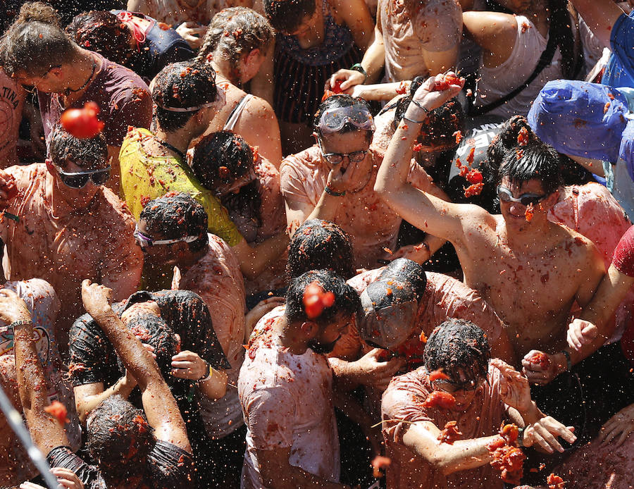 Buñol ha vivido este miércoles su fiesta más internacional. La Tomatina 2018 ha reunido a 20.000 personas que se han lanzado 145.000 kilos de tomate en la batalla menos cruenta de la historia. Ataviados con ropa vieja, gafas protectoras o chubasqueros, extranjeros y locales han disfrutado a tope de una fiesta que, además de diversión, genera un importante retorno económico a la localidad. 