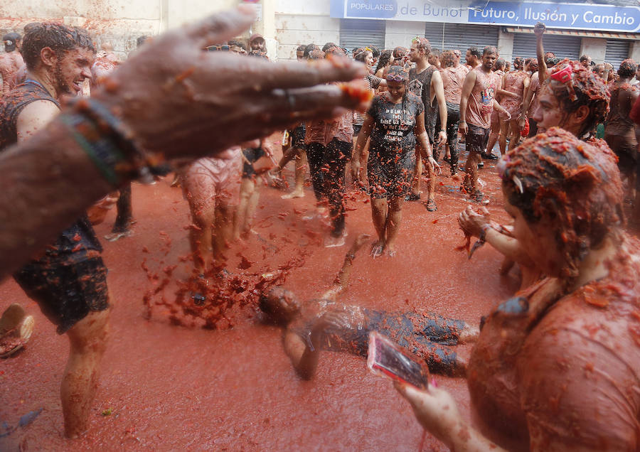 Buñol ha vivido este miércoles su fiesta más internacional. La Tomatina 2018 ha reunido a 20.000 personas que se han lanzado 145.000 kilos de tomate en la batalla menos cruenta de la historia. Ataviados con ropa vieja, gafas protectoras o chubasqueros, extranjeros y locales han disfrutado a tope de una fiesta que, además de diversión, genera un importante retorno económico a la localidad. 