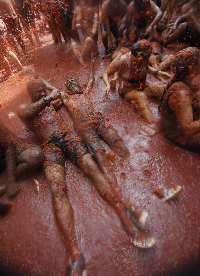 Buñol ha vivido este miércoles su fiesta más internacional. La Tomatina 2018 ha reunido a 20.000 personas que se han lanzado 145.000 kilos de tomate en la batalla menos cruenta de la historia. Ataviados con ropa vieja, gafas protectoras o chubasqueros, extranjeros y locales han disfrutado a tope de una fiesta que, además de diversión, genera un importante retorno económico a la localidad. 