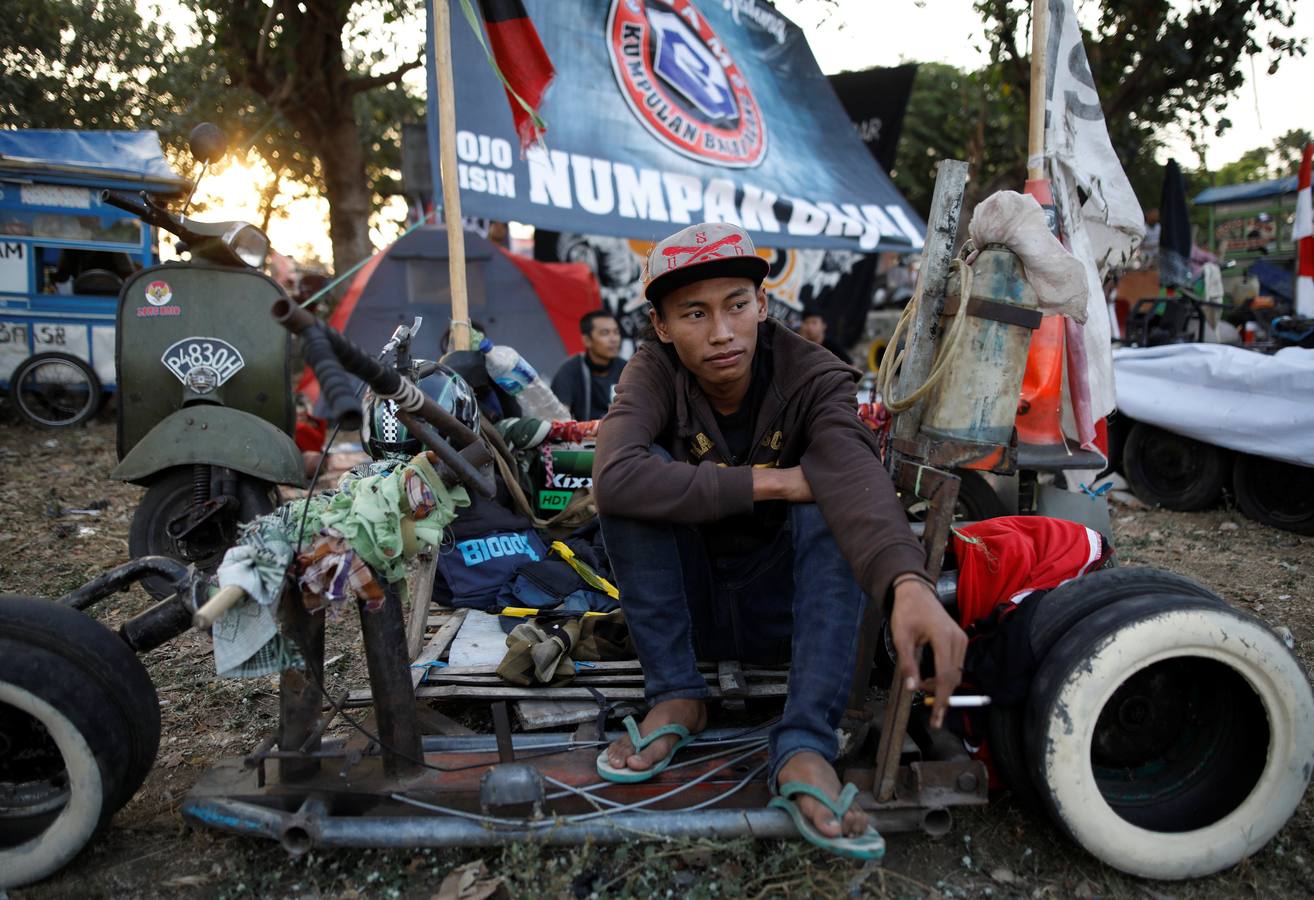 La Vespa convertida en 'monster-bike' al estilo 'Mad Max'. Cada año, desde adolescentes hasta abuelos indonesios se reúnen en la isla de Java para celebrar su pasión por el icónico 'scooter' italiano. Para algunos, es una especie de amor extremo, en el que los vehículos se personalizan o tunean para ver motos-monstruo sacadas de una distopía de Hollywood o una sociedad postapocalíptica. Cientos de entusiastas viajan al festival en Kediri y presumen de sus creaciones, desde Vespas antiguas restauradas hasta tanques de 'Mad Max' equipados con ametralladoras falsas, una docena de neumáticos adicionales o peluches de adorno.