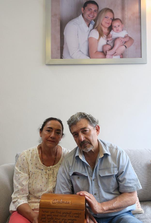 Los padres del acusado, bajo una foto de la pareja y su hijo. 