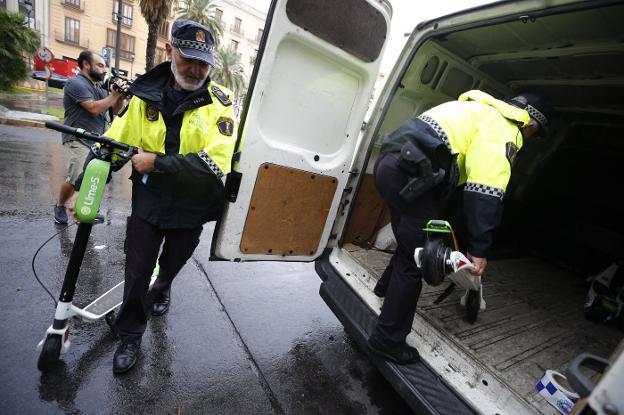 Agentes de Policía retirando los patinetes eléctricos de alquiler que no tienen permiso para operar en Valencia. 