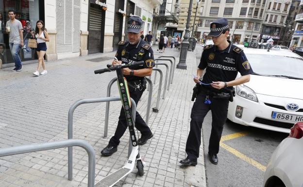 Los policías retiran patinetes en el centro de Valencia. 