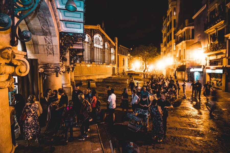 Numerosos valencianos y turistas abarrotan los mercados municipales de Valencia en la noche gastronómica y cultural programada este sábado en catorce recintos de la ciudad, el plato estrella del III Bonic/a Fest, que arrancó a las ocho de la tarde y se prolongará hasta la medianoche. La Fiesta de los Mercados Municipales, que persigue potenciar el comercio de proximidad y la alimentación saludable a través de los productos que se ofrecen en estos recintos, arrancó con colas a las puertas del Mercado Central, como en Ruzafa o el Cabanyal. 