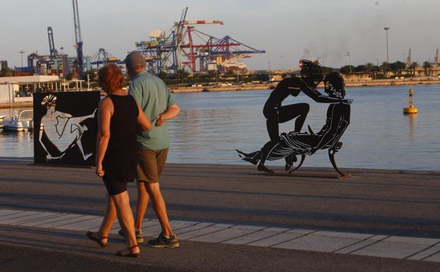 Una pareja pasa por delante de algunas de las obras. En los detalles, varios ejemplos más.