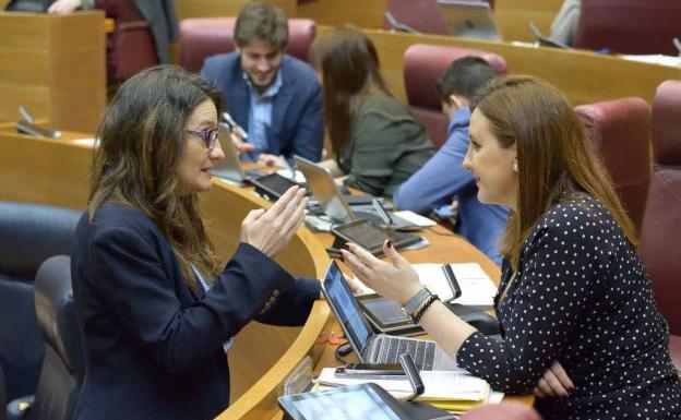 ónica Oltra y María José Català dialogan en Les Corts. 